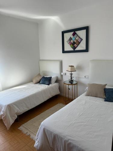 a room with two beds and a table with a lamp at Casa de la bis in A Guarda