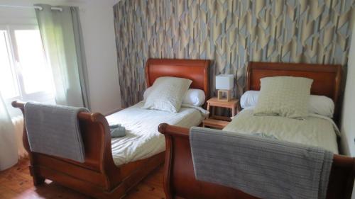 a bedroom with two beds and two chairs at Au petit moulin in Issigeac
