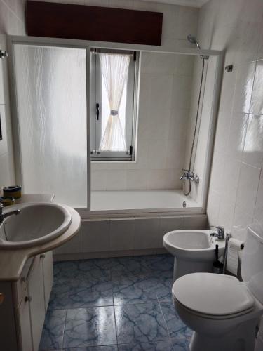 a bathroom with a sink and a toilet and a window at Casa de la bis in A Guarda