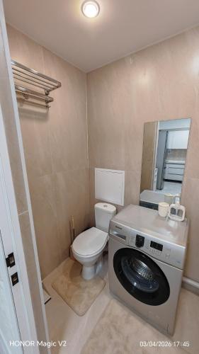 a bathroom with a toilet and a washing machine at Aktau 4-31 in Aktau
