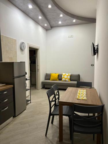 a kitchen and dining room with a table and a couch at B&B Mamie in Bellizzi