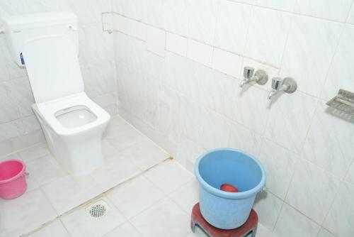 a bathroom with a toilet and a bucket in it at Hotel laxminarayan niwas in Shirdi