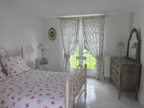 a bedroom with a pink bed and a window at Les 4 saisons in Menneville