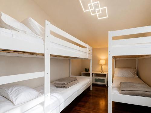 two white bunk beds in a room with a desk at Casa di Iaio - Wi-Fi Netflix Home Cinema in Gorizia