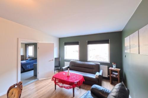 ein Wohnzimmer mit einer Couch und einem roten Tisch in der Unterkunft Gil guesthouse in Búðardalur