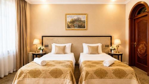 a hotel room with two beds and two lamps at Premier Hotel in Baku