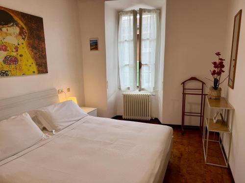 a bedroom with a white bed and a window at The Nest in Mandello del Lario