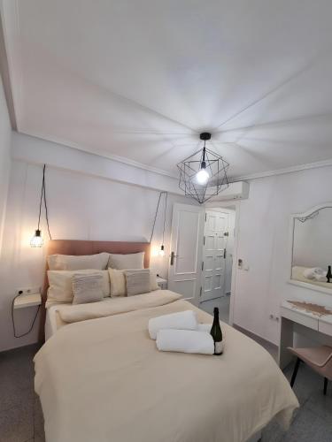 a white bedroom with two beds and a desk at Mar y Sol in Torrevieja