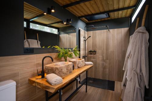 a bathroom with two sinks and a shower at Amaraxe Ecoglamping in Miñortos