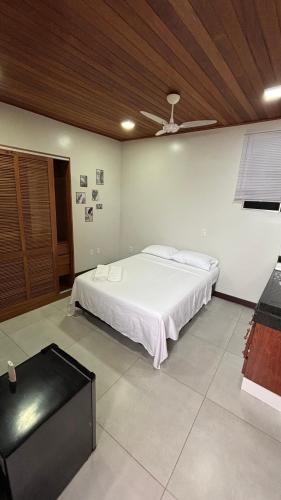 a bedroom with a white bed and a ceiling at Suítes Aymoré in Itacaré