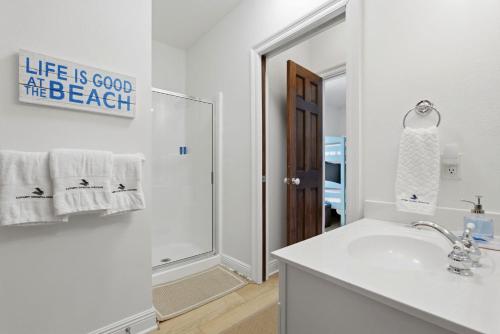 a white bathroom with a sink and a mirror at Riviera Dunes 503 in Perdido Key
