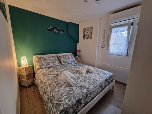 a bedroom with a bed and a green wall at La Rinascita HOUSE in Francavilla al Mare