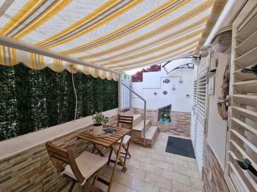 a patio with a table and chairs and awning at La Rinascita HOUSE in Francavilla al Mare