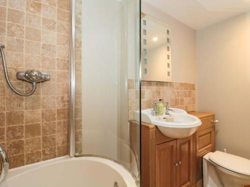 a bathroom with a tub and a sink and a shower at Riverside Barn in Gilwern