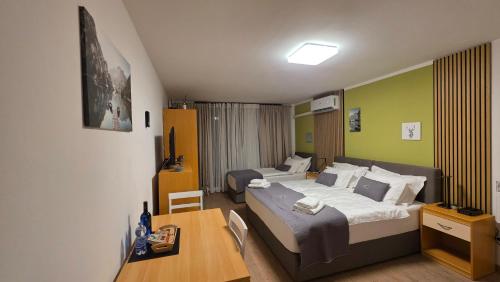 a hotel room with two beds and a desk at Vivo Bovec in Bovec