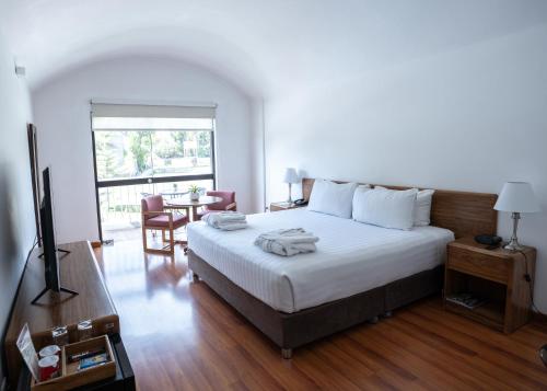a bedroom with a bed and a table and a window at El LAGO HOTEL by Luoxo in Arequipa