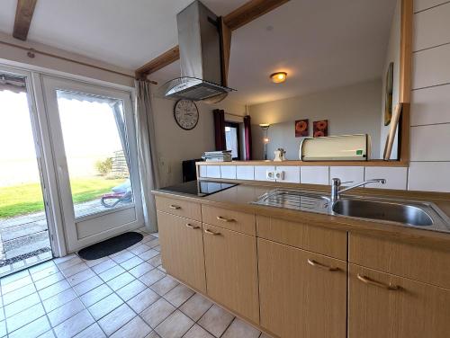 a kitchen with a sink and a large window at Nordseehof Reitz in Friedrichskoog