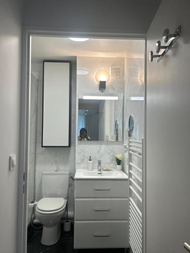 a bathroom with a toilet and a sink and a mirror at Studio Disney Paris in Bailly-Romainvilliers