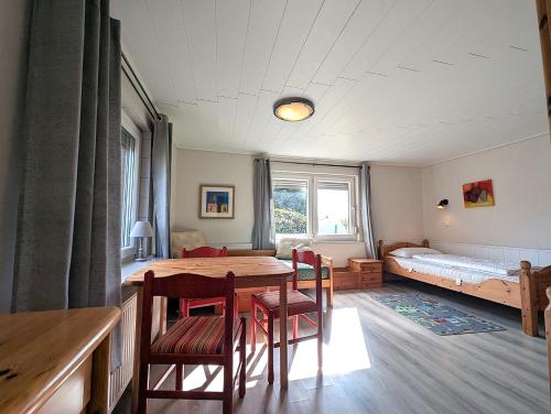 a room with a table and chairs and a bed at Nordseehof Reitz in Friedrichskoog