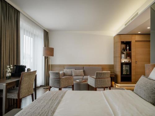a hotel room with a bed and a living room at IMLAUER HOTEL PITTER Salzburg in Salzburg