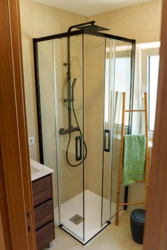a glass shower in a bathroom with a sink at SuCaSa Full house with terrace 5 min from centre in Coimbra