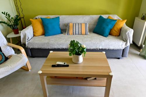 a living room with a couch with blue and orange pillows at Melrose maisonette by the sea in Anavissos in Anavyssos
