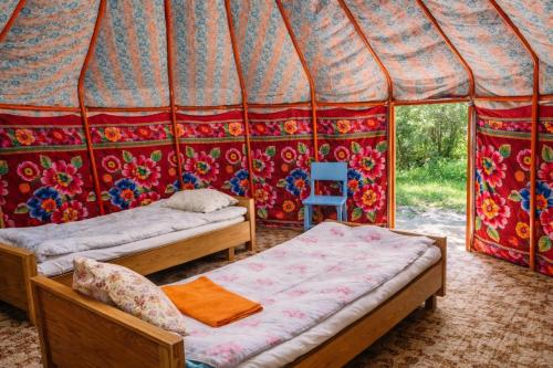 a room with two beds in a tent at Arista Yurt Camp in Karakol