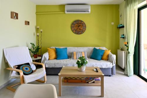 a living room with a couch and a table at Melrose maisonette by the sea in Anavissos in Anavyssos