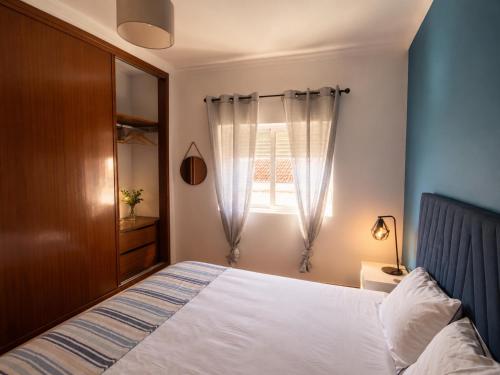 a bedroom with a bed and a window at Apartamento Vicentino in Vila Nova de Milfontes