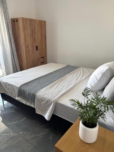 a bedroom with a bed and a table with a potted plant at Modern Panoramic Sea View Apartment with Large Terrace in Pag