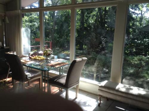 a dining room table with chairs in front of a large window at Charming Bedroom with Private Bathroom in Ann Arbor