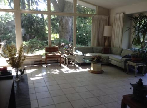 a living room with a couch and a large window at Charming Bedroom with Private Bathroom in Ann Arbor