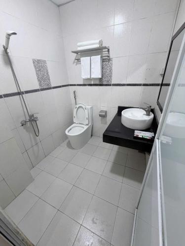 a white bathroom with a toilet and a sink at G9 home hotel in Hanoi