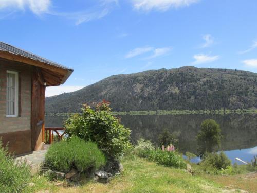 a house with a view of a mountain and a lake at Cabañas El Muelle in Cholila