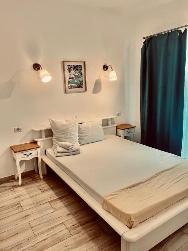 a bed in a bedroom with a blue curtain at EFORIE STUDIOS in Eforie Nord