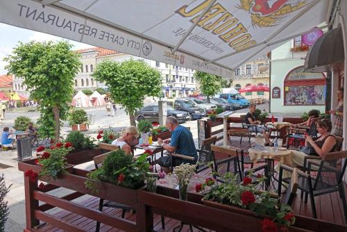 a group of people sitting at tables at a restaurant at Hotel City Pisek in Písek