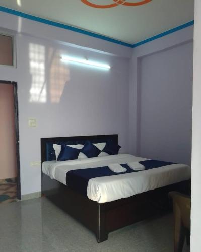 a bedroom with a bed with blue and white pillows at Shree mangalam homestay in Bhīm Tāl