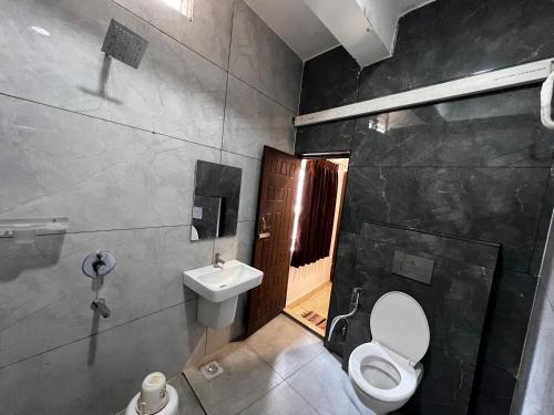 a bathroom with a toilet and a sink at Hotel Church Way Inn in Velankanni