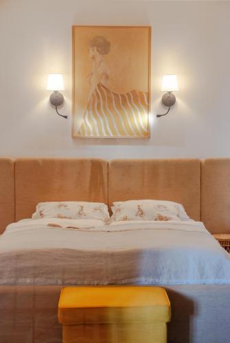 a bedroom with a bed with two lights on the wall at Anties Namai in Juodkrantė