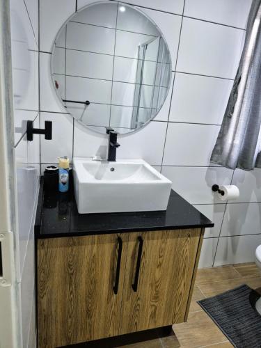 a bathroom with a sink and a mirror at Casa Kruger Lodge in Phalaborwa