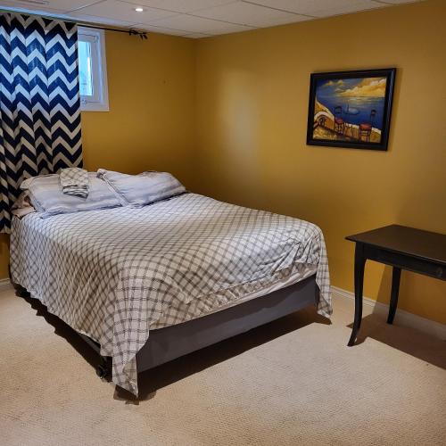 a bedroom with a bed and a table in it at My Home in Calgary