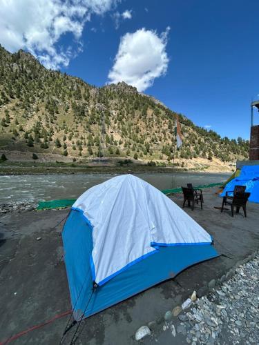 a blue tent sitting on the side of a river at Kishan Ganga Camping Site in Wāmpor