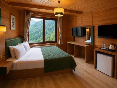 a bedroom with a bed and a large window at Ayder Doga Resort in Ayder Yaylasi