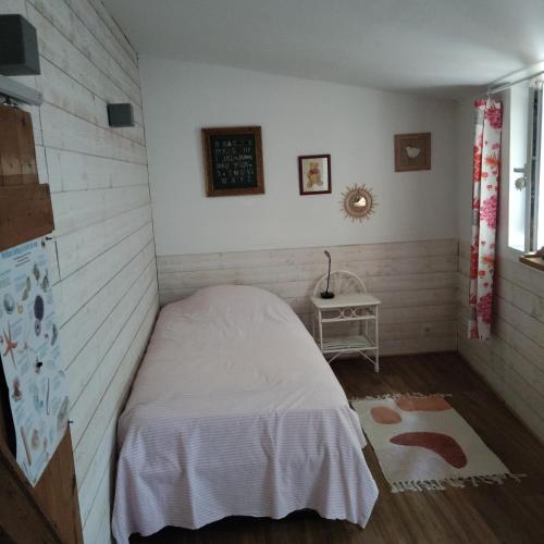 a bedroom with a white bed and a table at Petite maison en Luberon in Apt