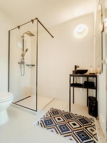 a bathroom with a glass shower and a rug at helloduna in Dunabogdány