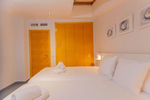 a bedroom with two white beds with white pillows at Stancia Carmen in Valencia