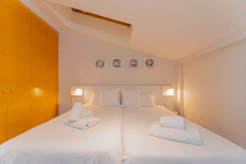 a bedroom with a large white bed with two white chairs at Stancia Carmen in Valencia
