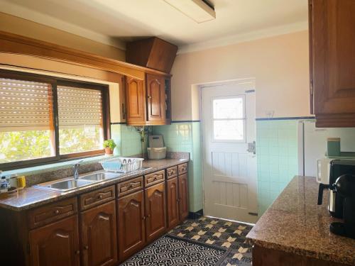 a kitchen with wooden cabinets and a sink and a window at Casa de férias in Monte