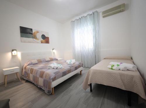 a bedroom with two beds and a window at Bellamorèa in Noto
