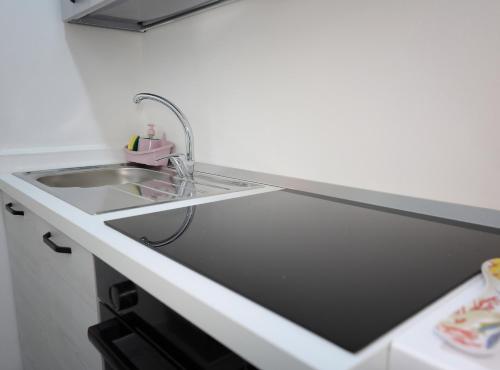 a kitchen with a sink and a counter top at Bellamorèa in Noto